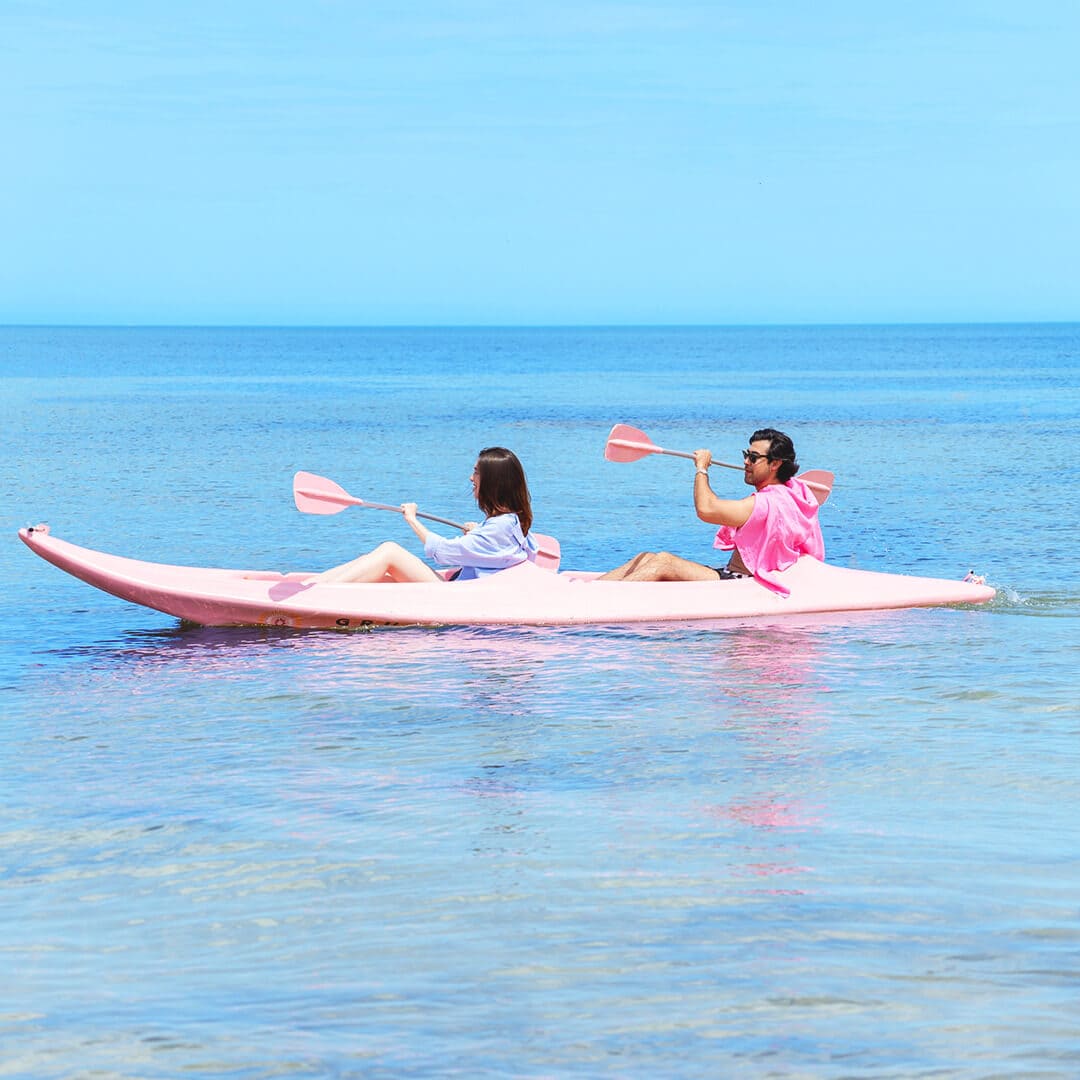 Pareja practicando kayak en las aguas tranquilas del Beach Club